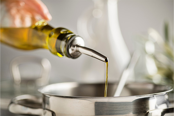Cooking oil being poured into a cooking pan.
