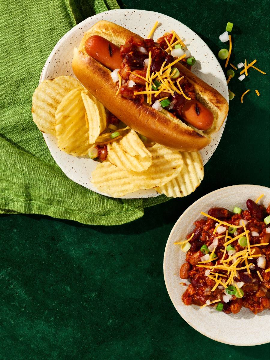 Veggie dog on a plate with chips.